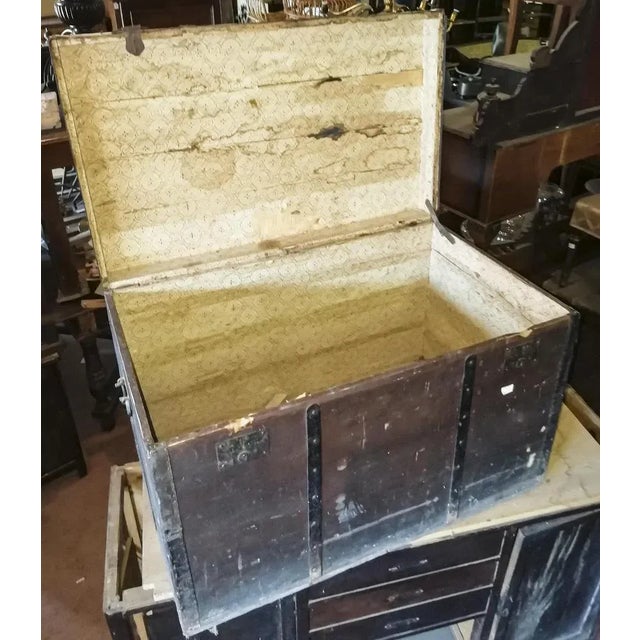 Black cash caseworks in solid wood with reinforcements and iron hinges of which a missing complete with side handles that...