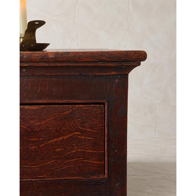 An English Georgian oak chest of drawers dating to the early-to-mid 18th century, circa 1720–1760. Its beautifully aged...