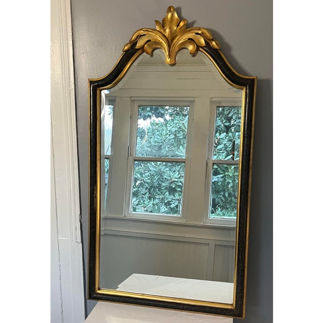 A 1960s Hollywood Regency neoclassical giltwood wall mirror featuring a hand-carved acanthus leaf crest and richly...