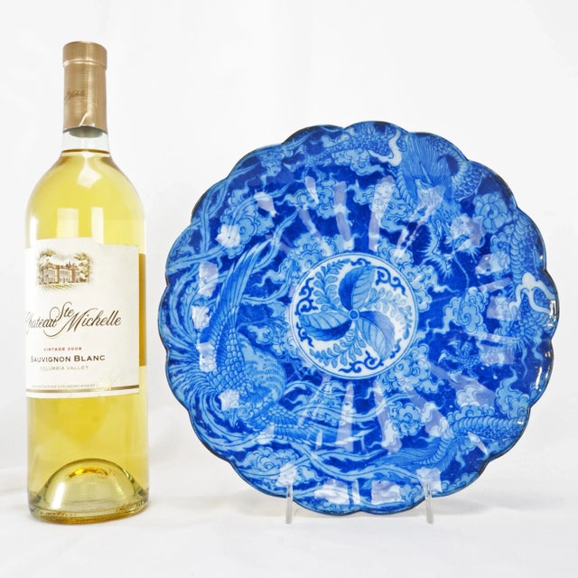 A molded blue and white porcelain plate with a scalloped edge that has been decorated in an early cobalt blue transferware...