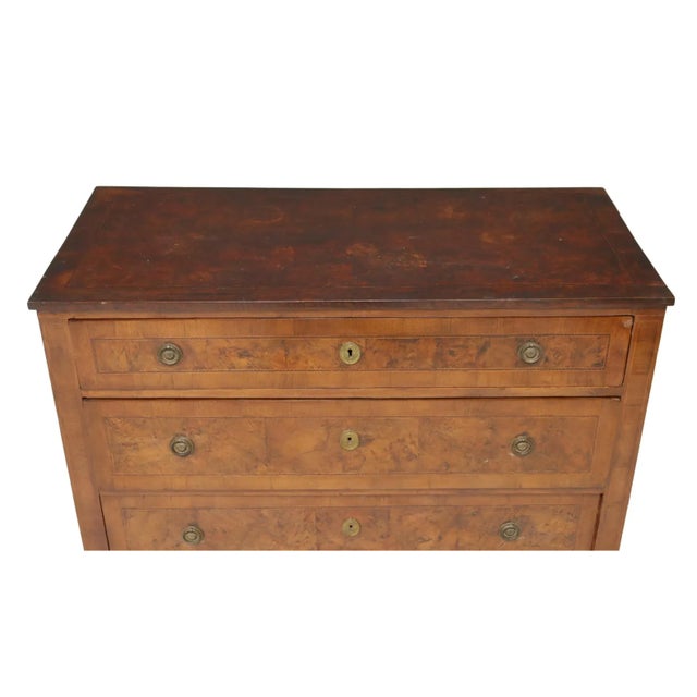 Italian Neoclassical walnut commode, early 19th c., the burled top over three drawers accented with string inlay, all...