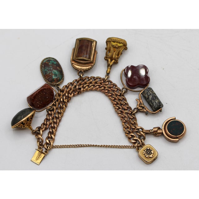 Circa 1920s gold filled charm bracelet made of watch fobs. Each watch fob set with semi-precious stones - agates,...