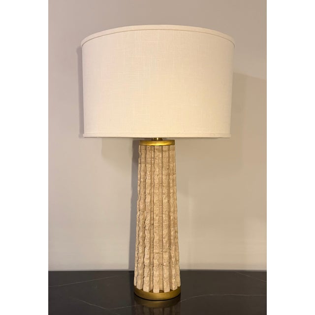 Studio A by Global Views Quarry Table Lamp in natural travertine with warm brass accents. The sculptural fluted stone base...
