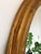 Elegant vintage oval mirror from Belgium, with a carved giltwood frame in a soft gold finish. Object: Mirror Style:...