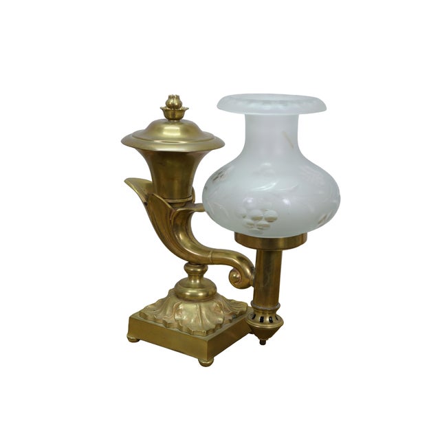 This pair of classical-style antique Argand lamps, dating to circa 1820–1830, is crafted from heavy cast gilt brass and...