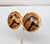 1980s round slightly domed goldtone orange and black striped clip earrings. Marked "YOSCA©" on the backs. Measure: 1 7/16...