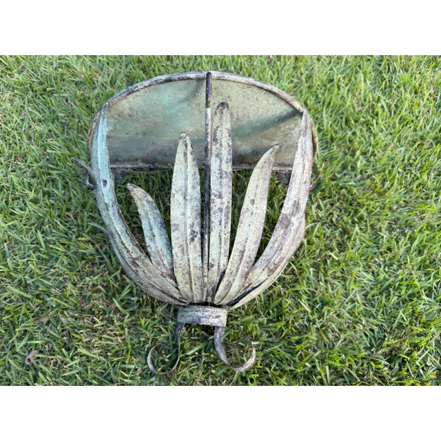 Vintage metal wall shelf featuring a sculptural leaf-form design with a naturally aged verdigris finish. Curving botanical...