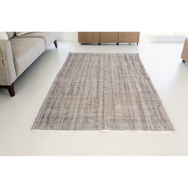 This is a vintage Turkish Oushak rug from the Mid 20th Century. The piece was hand-knotted.