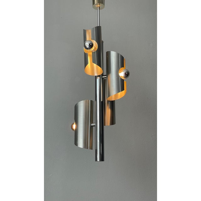 A sleek silver lamp featuring four elegant silver-top bulbs, offering a minimalist yet sophisticated design that...