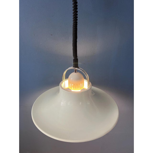 Beautiful white mid-century modern pendant lamp featuring elegant chrome details and a distinctive UFO-inspired design....