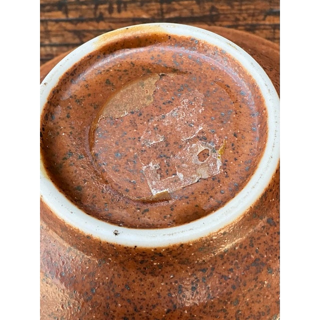 Exuding artisan craftsmanship and organic mid-century design, this vintage ceramic bowl features a warm, earthy studio...