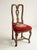 A set of four antique, traditional dining side chairs crafted in the style of early 18th century period Queen Anne...