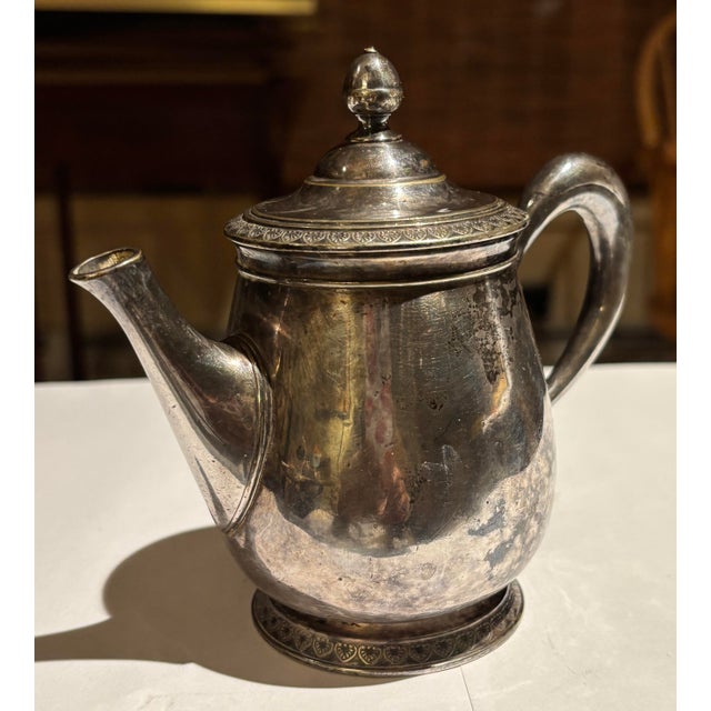 Vintage English silver-plated teapot in a classic rounded form with decorative rim detail. Features a matching monogram...