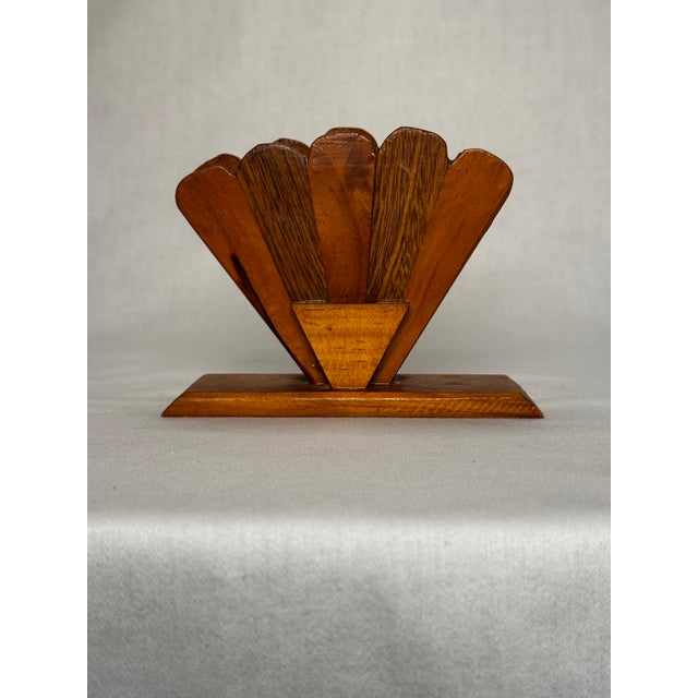 A beveled rectangular base holds a splayed arched blade fan to comprise the sides of this napkin holder. A small wood...