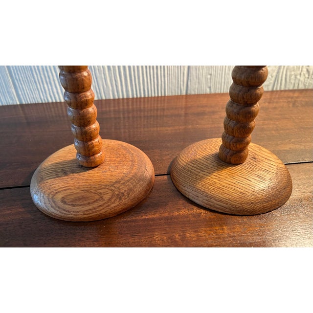 A pair of unique Victorian bobbin turned oak candlestick holders with turned round bases. 11" tall, base 4" wide.Brass...