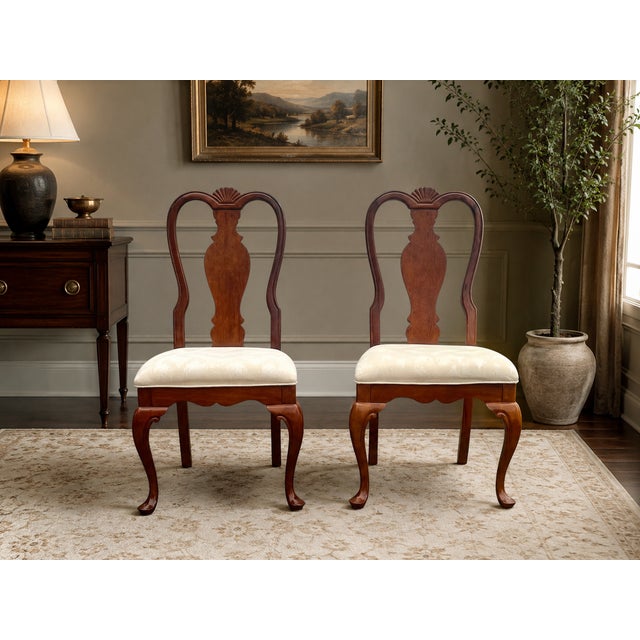 Elegant pair of vintage Ethan Allen dining chairs featuring classic Queen Anne styling and a warm cherry-toned finish....