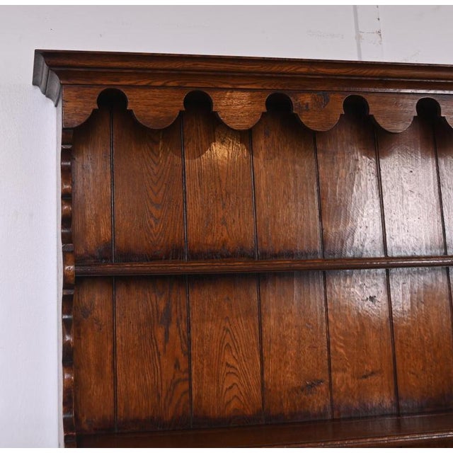 A handsome english country house oak dresser with integral plate rack above by renowned makers titmarsh & goodwin,...