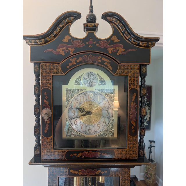 This is a mid-20th-century Chinoiserie black lacquer grandfather clock, a decorative style frequently imported by makers...