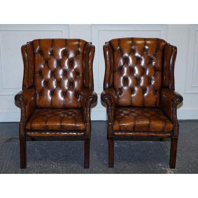 Antiques of London This elegant pair of wingback armchairs are crafted in the classic Georgian style, featuring...