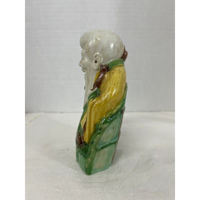 A single Chinese export porcelain figurine of a shou lao male figure with polychrome sancai style green yellow and brown...