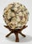 Round orb completely covered in various types of small sea shells. Orb sits on a collapsible wood twig stand. Age wear....