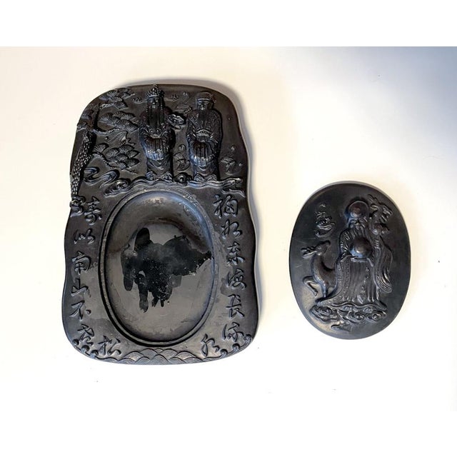 A black carved Chinese inkstone with an conforming oval cover circa early 20th century (late Qing to Republic period). The...