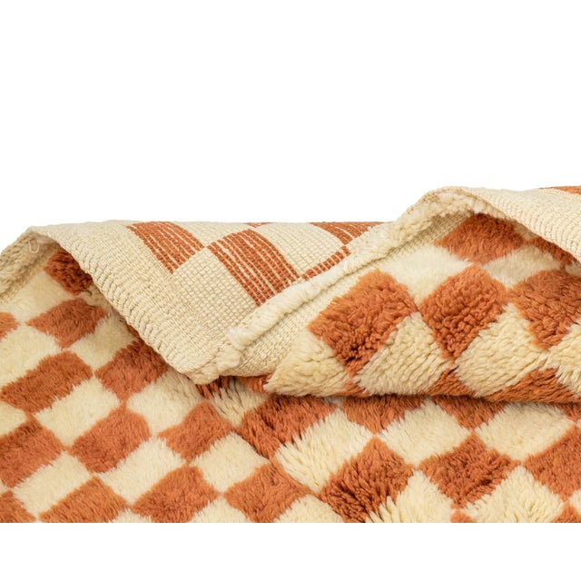Timeless hand-knotted wool rug with a checkered design in Sunlit Sienna and Ivory, offering a timeless, cozy aesthetic....