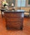 A French Empire three-drawer commode, circa 1810–1830, with tailored rectangular form and paw-foot base. Crafted from...