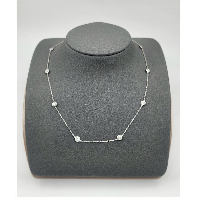 A sophisticated platinum necklace featuring 10 natural round-cut white diamonds totaling approximately 1.59 carats, with a...