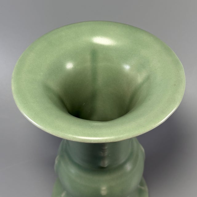 This vintage‑style celadon vase features a graceful flared opening, bulged middle section and glossy smooth green glaze....