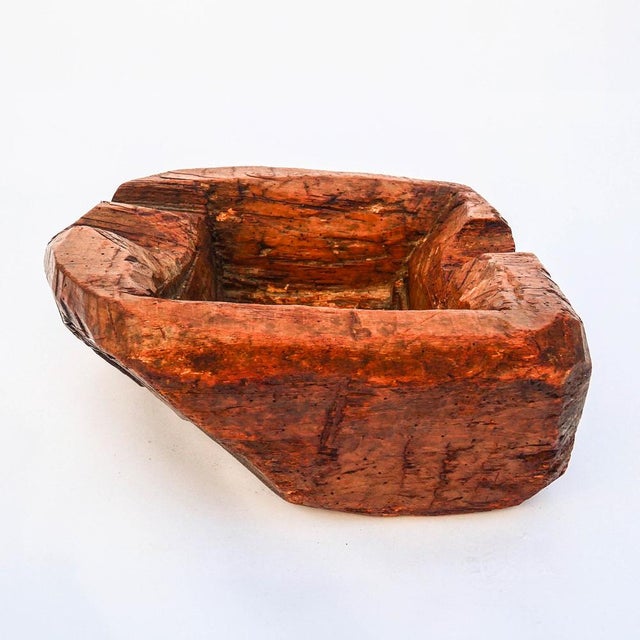 A solid wood container, carved from a single block, rectangular in shape with rounded corners, featuring a deep,...
