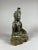 The Bronze Bodhisattva is seated upright in a lotus position or padmasana, a meditation pose on a base. The hands are in a...
