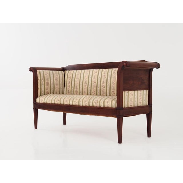 The sofa was made in the 1940s, Danish production. The structure and legs are made of solid mahogany wood. The sofa is...