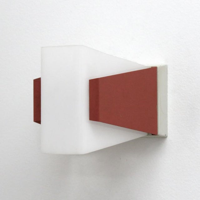 Minimalist, burnt orange and white wall sconces by Philips, in enameled metal and acrylic light covers, rewired porcelain...