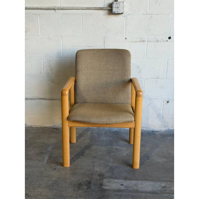 This comfortable armchair showcases a clean wooden frame paired with textured fabric upholstery. The organic lines and...