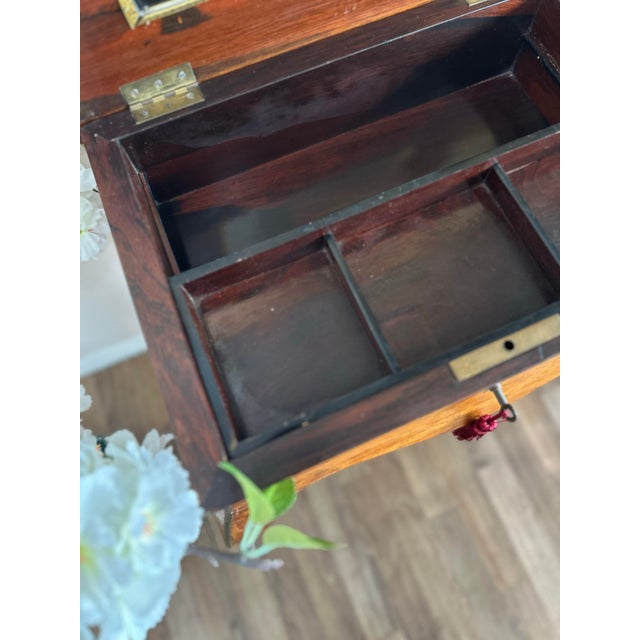 An elegant antique vanity table featuring beautifully figured wood, delicate string inlay, a shaped lift-top with inset...