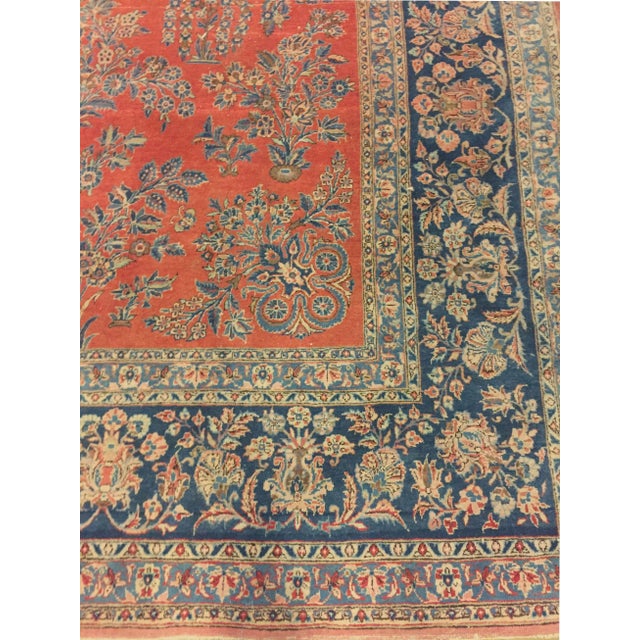 This Persian Sarouk carpet, dating back to circa 1920, showcases a traditional design rendered in rich shades of red and...