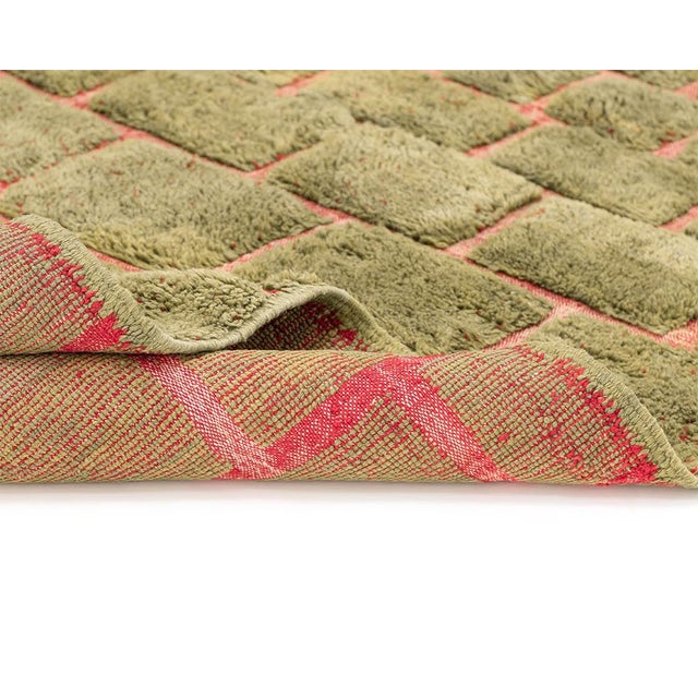 Vibrant hand-knotted rug featuring a hand-woven brick-like pattern in Olive Oasis and Carmin, offering a lush, textured...