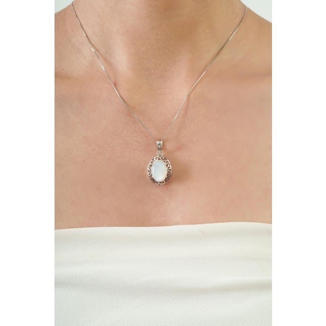 The Bohemian Natural Oval Rainbow Moonstone & Sterling Silver Filigree Pendant features a beautiful 5.68-carat Rainbow...