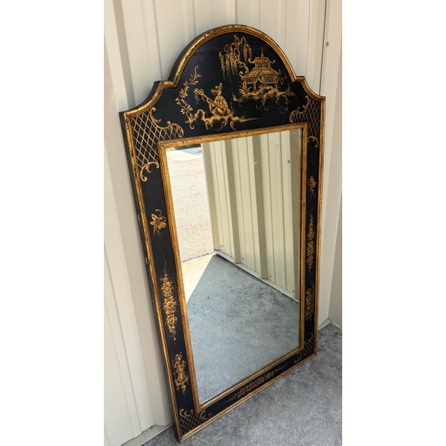 A striking vintage Italian Chinoiserie wall mirror featuring an elegant black lacquered frame embellished with finely...