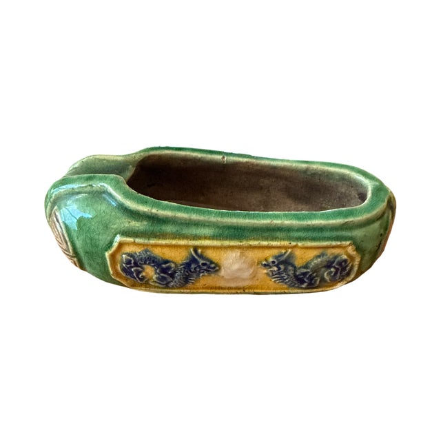 An intriguing antique Asian pottery scholar's object featuring a rich green crackle glaze, molded geometric end...