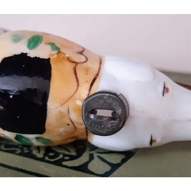 This vintage Christmas ornament features an elephant made of white milk glass, standing with its trunk raised. The...