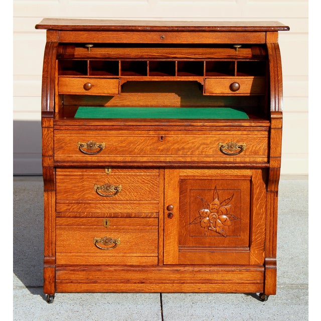 This exceptional antique roll top secretary desk is crafted from solid quarter-sawn oak, celebrated for its dramatic tiger...