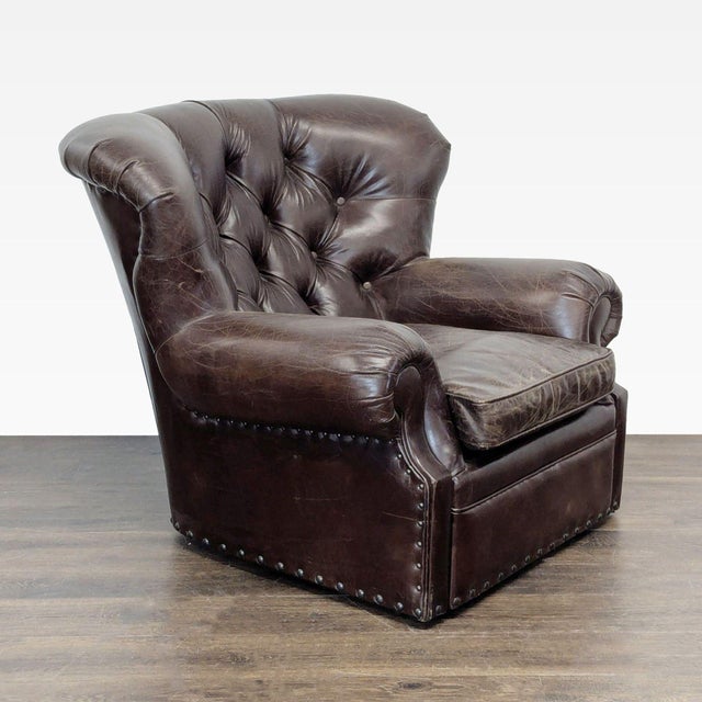 This classic lounge chair features rich brown leather upholstery with deep tufted backing and rolled arms for extra...
