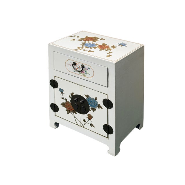 This elegant, vintage-style Chinese nightstand or accent cabinet features a clean, off-white painted finish adorned with...