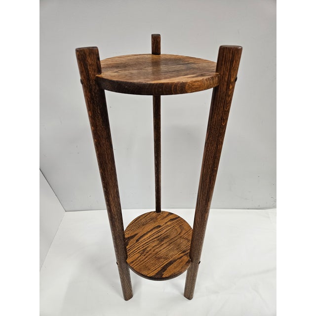 This tall two-tier oak plant stand features oval or oblong supports and plenty of character. The stand is 32 inches tall....