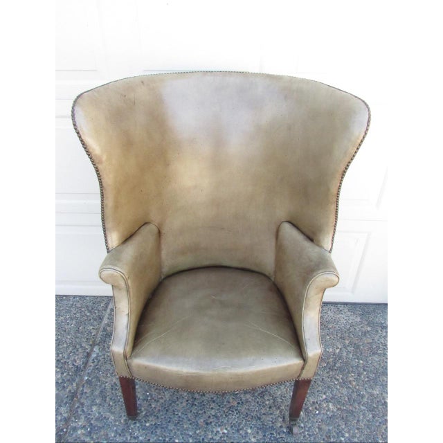 Antique English leather wingback armchair, c.1820 A classic English George lll wingback armchair with an arched high back,...