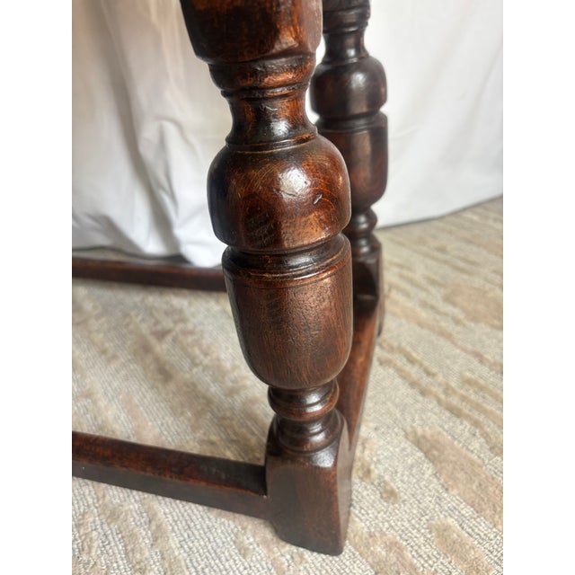 An unusually large Jacobean style solid oak Joint Stool, mortise, tenon and pegged construction, the overhanging top above...