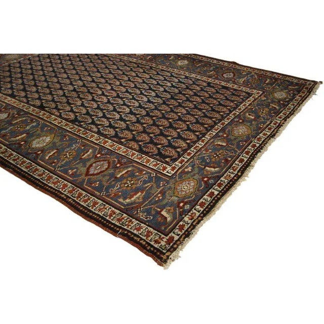 antique Persian Heriz with Boteh pattern. This hand knotted wool antique Persian Heriz rug features an all-over geometric...