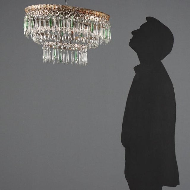 Empire style chandelier crafted from gilt iron and sheet metal, adorned with a harmonious arrangement of leaves and...